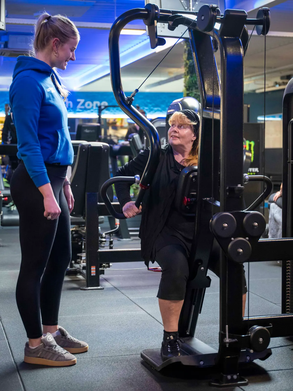 Trainer helpt een lid op een machine bij UltraGym Hardenberg