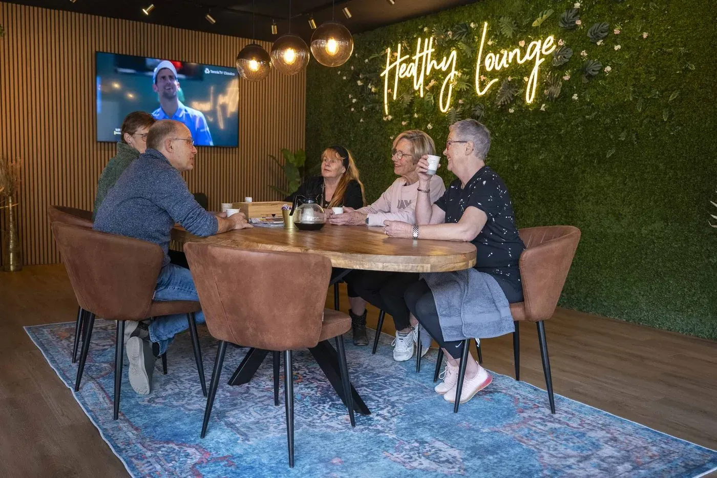 Leden zitten samen aan tafel in de Healthy Lounge
